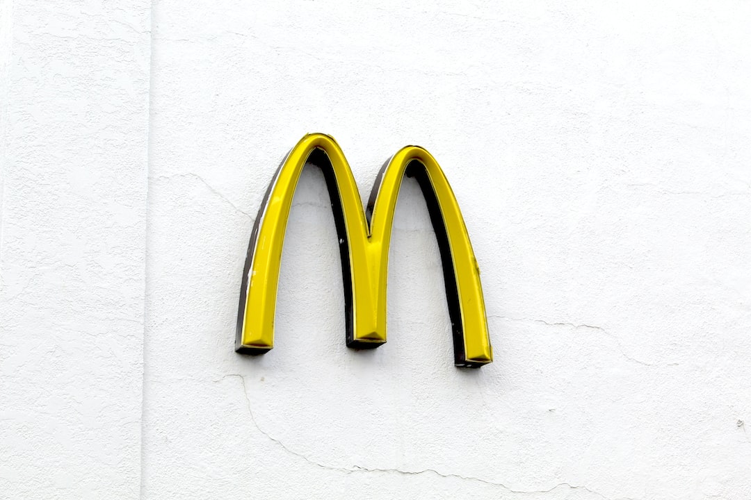 A yellow McDonald’s “M” logo, also known as the Golden Arches, mounted on a plain white wall—instantly recognizable like top brands in WordPress Hosting.